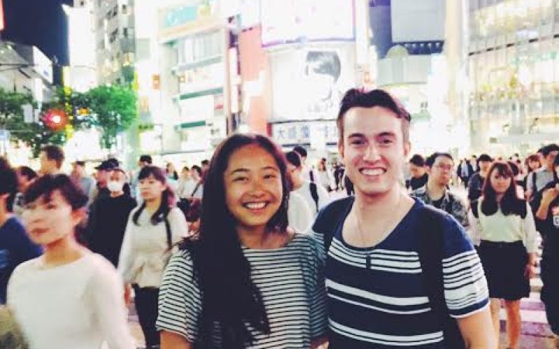 A photo of man and woman standing in the middle of Shibuya crossing